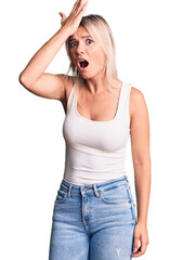 Poster - Young beautiful blonde woman wearing casual sleeveless t-shirt surprised with hand on head for mistake, remember error. forgot, bad memory concept.