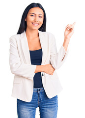 Young beautiful latin girl wearing business clothes smiling happy pointing with hand and finger to the side