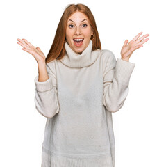 Wall Mural - Young irish woman wearing casual winter sweater celebrating crazy and amazed for success with arms raised and open eyes screaming excited. winner concept