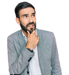 Wall Mural - Young hispanic man wearing business clothes thinking worried about a question, concerned and nervous with hand on chin