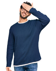 Sticker - Young hispanic man wearing casual clothes and glasses smiling and laughing with hand on face covering eyes for surprise. blind concept.