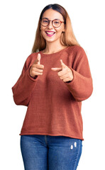 Sticker - Beautiful young woman wearing casual clothes and glasses pointing fingers to camera with happy and funny face. good energy and vibes.