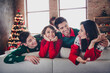 © deagreez - Photo of positive funky people sitting cozy sofa cuddle communicate christmas time miracle flat indoors