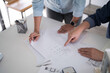 © Pichsakul - Male engineer architect pointing on blueprint to explaining sketching about interior architectural building while discussion to analysis technical for construction plan with partner in workplace site
