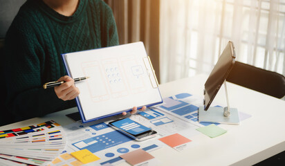 Wall Mural - view of ui developer team brainstorming on their project with laptop, smartphone and digital tablet.