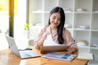 © Wasana - Asian businesswoman sitting and working check documents analyze market reports. Review and compare report data.