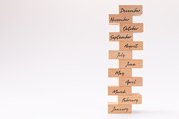 Wooden blocks with months according to calendar year. Bitcoin coin and wooden block. Concept of financial trends. Names of months are marked on wooden blocks.