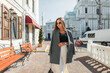 © alones - Stylish beautiful business lady with cool sunglasses in fashion casual clothes with a blazer walks in the city. Pretty chic urban woman in sunny spring day