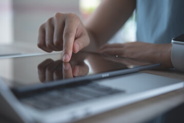 Poster - Business woman finger touching on digital tablet and working on laptop computer on office table