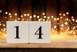 © E_Katsiaryna - Wooden cubes with number 14 on wooden table and defocused lights in the background. Romantic love concept, Valentine day. Valentines Day background