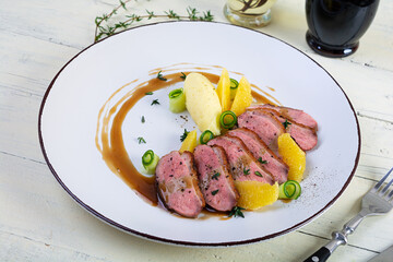 Wall Mural - Roast duck fillet with mashed potato and orange sauce on wooden background