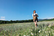 © dmitriisimakov - Woman in the field in flowers in nature walking journey