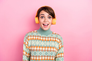 Poster - Photo of young woman brown bob hair wear print pullover winter season surprised listen loud music earphones isolated on pink color background