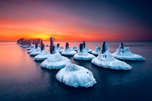 Ice Covered Wooden Posts Of An Old Pier In Baltic Sea At Sunset, Sventoji, Lithuania