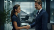 © MP Studio - A woman and a man in suits shake hands in the office
