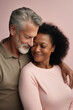 © LotusBlanc - White Man and Black Woman Hugging. Multiracial Mature Couple Smiling and Embracing Love on Pink Background.
