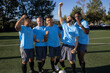 © Mat Hayward - Group of five men on a soccer team. The players are standing proudly together in a blue uniform on the field.