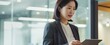 korean business woman financial manager using digital tablet working in office. professional businesswoman executive holding tab technology device standing at work. generative AI