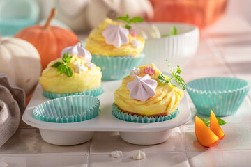 Wall Mural - Sweet pumpkin muffins decorated with sprinkles and meringues.