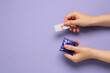 Woman holding condom and contraceptive pills on violet background, top view with space for text. Choosing birth control method