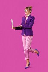 Young woman dressed as doll using laptop on purple background