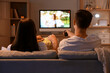 © Pixel-Shot - Couple with popcorn watching TV at home in evening