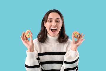 Sticker - Happy young woman with tasty cookies on blue background