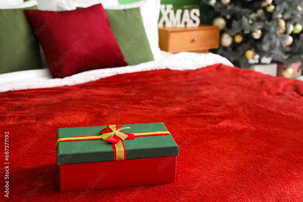 Christmas gift box on bed in room, closeup