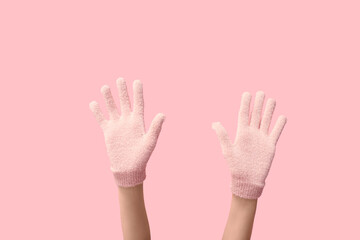 Wall Mural - Hands in warm gloves on pink background