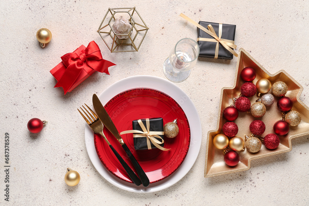 Beautiful table setting with Christmas balls and gift boxes on white background
