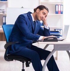 Wall Mural - Young male businessman working in the office