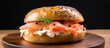Smoked salmon and cream cheese on a plain bagel with dill and capers for breakfast.