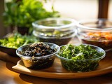 Fototapeta  - Japanese raw vegan organic delicious and tasty marinated chuka wakame salad and seaweed nori salad dishes in glass bowls on a wooden table
