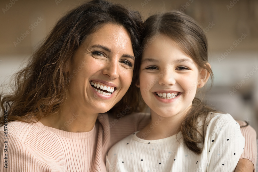 Positive beautiful mom and happy tween kid girl looking at camera ...