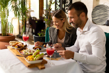 Wall Mural - Young couple having lunch and drinking fresh squeezed juice in the restaurant