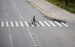 © nuclear_lily - Man crosses the road at a pedestrian crossing and carries a bicycle next to him. View from above.