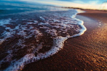 Wall Mural - Sea coast with waves at sunset, close-up view