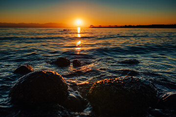 Canvas Print - Rocky shore of lake in sunset light