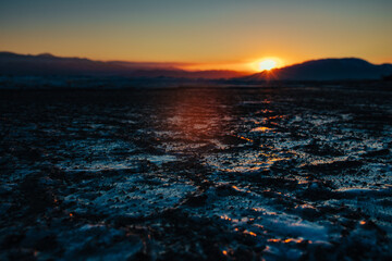 Canvas Print - Dark ice on lake in cold winter weather, dramatic sunset light