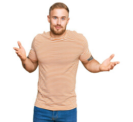 Wall Mural - Young irish man wearing casual clothes clueless and confused expression with arms and hands raised. doubt concept.