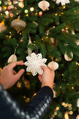 Wall Mural - hands decorate and hang a craft christmas tree toy star on the christmas tree. branches with decorat