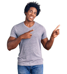 Sticker - Handsome african american man with afro hair wearing casual clothes smiling and looking at the camera pointing with two hands and fingers to the side.