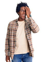 Sticker - Handsome african american man with afro hair wearing casual clothes and glasses covering one eye with hand, confident smile on face and surprise emotion.