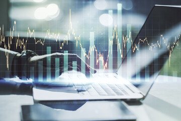Poster - Abstract creative financial graph with hand typing on laptop on background, financial and trading concept. Multiexposure