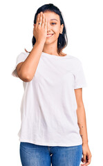 Canvas Print - Young woman wearing casual clothes covering one eye with hand, confident smile on face and surprise emotion.