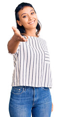 Poster - Young woman wearing casual clothes smiling cheerful offering palm hand giving assistance and acceptance.