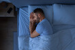 © Prostock-studio - Guy Sleeping Holding Hands Near Face Enjoying Rest In Bedroom