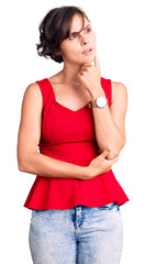 Wall Mural - Beautiful young woman with short hair wearing casual style with sleeveless shirt with hand on chin thinking about question, pensive expression. smiling with thoughtful face. doubt concept.