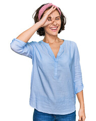 Sticker - Young hispanic woman wearing casual clothes smiling happy doing ok sign with hand on eye looking through fingers