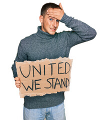 Poster - Young blond man holding united we stand banner stressed and frustrated with hand on head, surprised and angry face